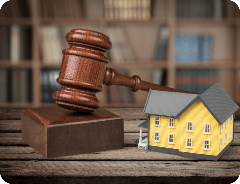A wooden gavel next to a yellow house.